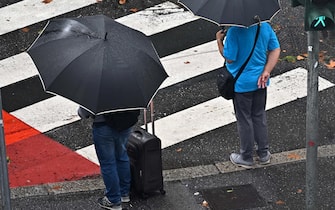 Two people under an umbrella after the storm, in Genoa, Italy, 28 August 2023. ANSA/ LUCA ZENNARO