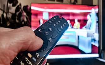15 February 2023, Hamburg: One hand operates the remote control of a television set. Photo: Markus Scholz/dpa/picture alliance/dpa | Markus Scholz (Photo by Markus Scholz/picture alliance via Getty Images)