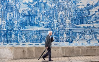 PORTO, PORTUGAL: Man passes azulejos Portuguese blue and white wall tiles of Capela das Almas de Santa Catarina  - St Catherine's Chapel in Porto, Portugal.  (Photo by Tim Graham/Getty Images)