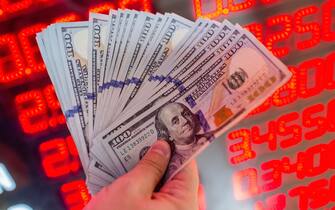 A man shows dollar banknotes at a currency exchange office in Istanbul, on August 8, 2018. - The Turkish lira on August 1 slumped to record lows of 5,0 against the dollar as the US hit Turkey's justice and interior ministers with sanctions over the case of an American pastor on trial for terror-related charges. (Photo by Yasin AKGUL / AFP)        (Photo credit should read YASIN AKGUL/AFP via Getty Images)