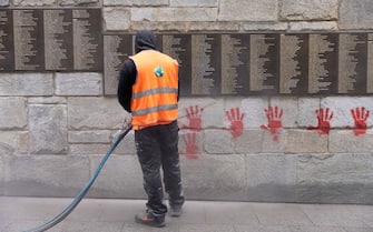 A city employee is at work to clean the "Wall of the Righteous" (Mur des Justes) covered with Red hands graffitis outside the Shoah memorial in Paris, on May 14, 2024, after the monument was vandalized overnight with the president of the Representative Council of French Jewish Institutions (CRIF) denouncing the act as antisemitic. (Photo by Antonin UTZ / AFP) (Photo by ANTONIN UTZ/AFP via Getty Images)