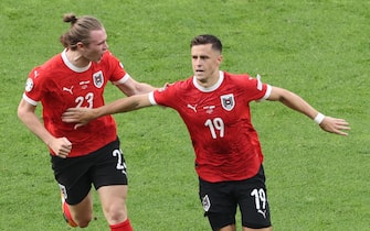 epa11428687 Christoph Baumgartner (R) of Austria celebrates after scoring the 2-1 lead during the UEFA EURO 2024 group D soccer match between Poland and Austria, in Berlin, Germany, 21 June 2024.  EPA/ABEDIN TAHERKENAREH