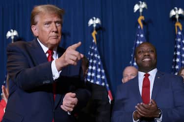 COLUMBIA, SOUTH CAROLINA - FEBRUARY 24: Republican presidential candidate and former President Donald Trump gestures to supporters as Sen. Tim Scott (R-SC) looks on during an election night watch party at the State Fairgrounds on February 24, 2024 in Columbia, South Carolina. Trump defeated Republican presidential candidate, former U.N. Ambassador Nikki Haley in her home state as South Carolina held its primary today.  (Photo by Win McNamee/Getty Images)