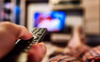 Switching TV channels on TV with finger on remote controller