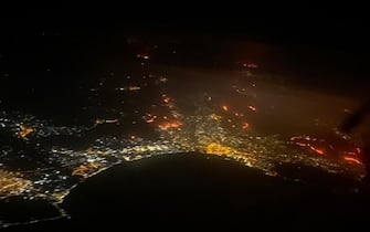 Una veduta dall'alto del vasto incendio che si è sviluppato sulle montagne attorno all'aeroporto Falcone - Borsellino di Palermo è arrivato a lambire la zona perimetrale dello scalo che è stato chiuso al traffico, Palermo 25 luglio 2023 ANSA/GIORGIANA CRISTALLI/STRINGER