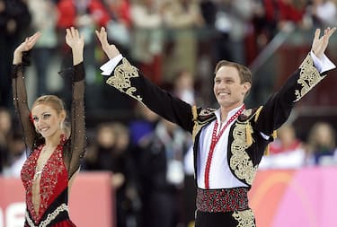 Turin, ITALY:  Gold medalists Russian pair Tatiana Navka and Roman Kostomarov celebrate on the podium of the Ice Dancing Free Dance event in the Figure Skating competition at the 2006 Winter Olympics, 20 February 2006 at the Palavela in Turin. US pair Tanith Belbin and Benjamin Agosto won the silver medal and Ukrainian pair Elena Grushina and Ruslan Goncharov took the bronze.    AFP PHOTO GOH CHAI HIN  (Photo credit should read GOH CHAI HIN/AFP via Getty Images)