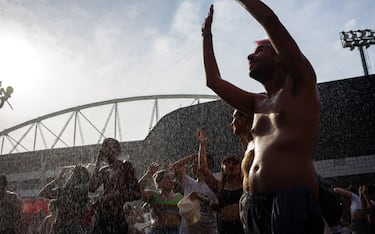 Fans of US singer Taylor Swift cool off as they queue outside the Nilton Santos Olympic Stadium before Swift's concert, "Taylor Swift: The Eras Tour", amid a heat wave in Rio de Janeiro on November 18, 2023. American superstar Taylor Swift on Saturday was mourning the death of a 23-year-old fan during her first show in Brazil before a crowd of 60,000. The death occurred as much of central and southeastern Brazil has been suffering an unusually oppressive springtime heat wave. (Photo by Tercio TEIXEIRA / AFP) (Photo by TERCIO TEIXEIRA/AFP via Getty Images)