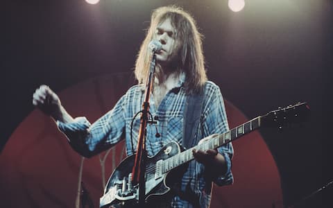 Canadian singer-songwriter and musician Neil Young performs on stage with Crazy Horse at Hammersmith Odeon, London, 28th March 1976. (Photo by Michael Putland/Getty Images) 
