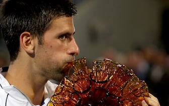 World top seeded Novak Djokovic of Serbia kisses his trophy after beating David Ferrer of Spain during their  final game  in the Mubadala Abu Dhabi Tennis Champisonship in Abu Dhabi, December 31, 2011.          AFP PHOTO/MARWAN NAAMANI (Photo credit should read MARWAN NAAMANI/AFP via Getty Images)