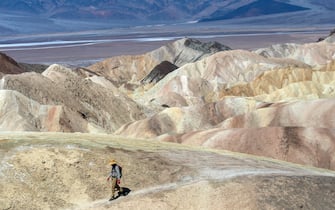 DeathÂ Valley, CA - July 18: Steve Curry, 71, of Sunland, is walking to Zabriskie Point in Death Valley National Park on Tuesday, July 18, 2023, in DeathÂ Valley, CA. It was well over 100 degrees by 10:00 am today. All the other visitors were walking up the paved path to the top of the viewing vista. Curry kicked a difference course. (Francine Orr / Los Angeles Times via Getty Images)