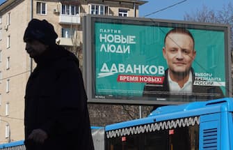 epa11218428 A man walks in front of a campaign poster of presidential candidate, the 'New People' political party Vladislav Davankov, in Moscow, Russia, 13 March 2024. The Russian presidential elections will be held from 15 to 17 March 2024.  EPA/MAXIM SHIPENKOV