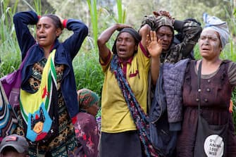 This undated handout photo taken by the UN Development Programme and released on May 28, 2024 shows locals reacting during search and rescue efforts at the site of a landslide at Mulitaka village in the region of Maip Mulitaka, in Papua New Guinea's Enga Province. Papua New Guinea moved to evacuate an estimated 7,900 people from remote villages near the site of a deadly landslide on May 28, as authorities warned of further slips. Some 2,000 people are already feared buried in a landslide that destroyed a remote highland community in the early hours of May 24. (Photo by Handout / UN DEVELOPMENT PROGRAMME / AFP) / RESTRICTED TO EDITORIAL USE - MANDATORY CREDIT "AFP PHOTO / UN DEVELOPMENT PROGRAMME  - NO MARKETING NO ADVERTISING CAMPAIGNS - DISTRIBUTED AS A SERVICE TO CLIENTS - NO ARCHIVE