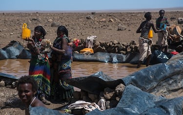 YANGUDI RASSA NATIONAL PARK, ETHIOPIA - MARCH 02: Somali people collecting water in a tank in the desert, afar region, yangudi rassa national park, Ethiopia on March 2, 2016 in Yangudi Rassa National Park, Ethiopia.  (Photo by Eric Lafforgue/Art in All of Us/Corbis via Getty Images)
