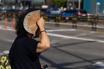 A pedestrian holds a fan for shade in Seoul, South Korea, on Thursday, Aug. 3, 2023. South Korea raised itsÂ heatÂ waveÂ warning to the highest level for the first time in four years earlier this week, with some parts of the nation experiencing temperatures above 38C (100.4F). Photographer: SeongJoon Cho/Bloomberg via Getty Images