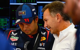 BAHRAIN INTERNATIONAL CIRCUIT, BAHRAIN - FEBRUARY 22: Sergio Perez, Red Bull Racing, talks to Christian Horner, Team Principal, Red Bull Racing, in the garage during the Pre-Season Test at Bahrain International Circuit on Thursday February 22, 2024 in Sakhir, Bahrain. (Photo by Sam Bloxham / LAT Images)