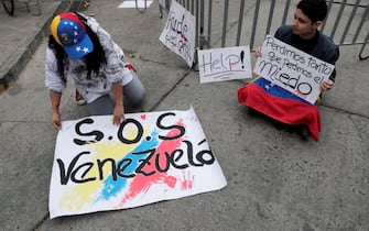 epa11510165 A couple of Venezuelan citizens hold signs outside the Venezuelan embassy in the Providencia neighborhood in Santiago, Chile, 30 July 2024. The Venezuelan embassy in Chile announced the suspension of its operations on 29 July. The National Electoral Council (CNE) proclaimed that Nicolas Maduro was re-elected president of Venezuela following elections held on 28 July. The banner (R) reads 'We lost so much that we lost fear'.  EPA/ELVIS GONZALEZ