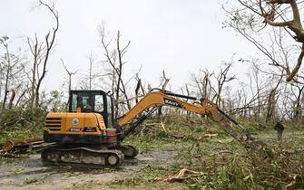 A driver operates heavy machinery to clear fallen trees in Sittwe, in Myanmar's Rakhine state, on May 15, 2023, after cyclone Mocha made a landfall. Cyclone Mocha made landfall between Cox's Bazar in Bangladesh and Myanmar's Sittwe carrying winds of up to 195 kilometres (120 miles) per hour, the biggest storm to hit the Bay of Bengal in more than a decade. (Photo by Sai Aung MAIN / AFP) (Photo by SAI AUNG MAIN/AFP via Getty Images)