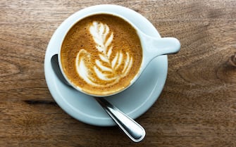 Caffè macchiato in a white cup on a wooden table