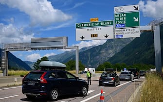This picture taken on July 30, 2023 a policeman directing cars towards the waiting line to enter the Mont-Blanc tunnel in Chamonix, Haute-Savoie. (Photo by Emmanuel DUNAND / AFP) (Photo by EMMANUEL DUNAND/AFP via Getty Images)