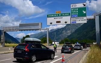 This picture taken on July 30, 2023 a policeman directing cars towards the waiting line to enter the Mont-Blanc tunnel in Chamonix, Haute-Savoie. (Photo by Emmanuel DUNAND / AFP) (Photo by EMMANUEL DUNAND/AFP via Getty Images)