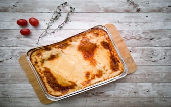 Freshly baked homemade lasagna bolognese on wooden background. Top
