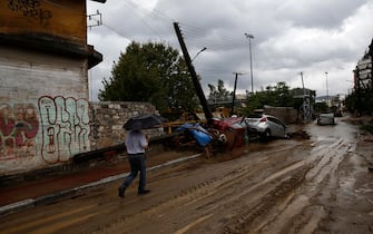 epa10843204 A man walks through a flooded road during the storm named Daniel in the area of Volos, Magnesia, Greece, 06 September 2023. The storm 'Daniel' sweeping through most of Greece with heavy rain and lightning caused extensive damage in the power network at Volos, Mt. Pilio, elsewhere in the Magnissia prefecture, as well as in the Sporades Islands.  EPA/YANNIS KOLESIDIS