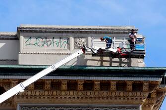 Lavori di pulizia dei graffiti sul frontone della Galleria Vittorio Emanuele II a Milano, 9 agosto 2023. ANSA/MOURAD BALTI TOUATI