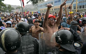 TOPSHOT - Opponents of Venezuelan President Nicolas Maduro's government protest at the Catia neighborhood in Caracas on July 29, 2024, a day after the Venezuelan presidential election. Protests erupted in parts of Caracas Monday against the re-election victory claimed by Venezuelan President Nicolas Maduro but disputed by the opposition and questioned internationally, AFP journalists observed. (Photo by YURI CORTEZ / AFP)