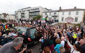 Fans of singer Sinead O'Connor line the streets for a "last goodbye" to the Irish singer as her funeral cortege passes through her former hometown of Bray, Co Wicklow, ahead of a private burial service. Picture date: Tuesday August 8, 2023.