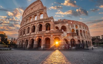 Rome, Italy at the Colosseum Amphitheater with the sunrise through the entranceway. 