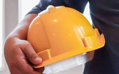 Yellow hard plastic safety helmets sit on work desks in office intended for architects and engineers to wear when entering construction sites as safety precaution because hard hats protect the head.