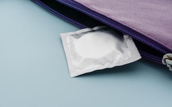 Condom in a purse. Pregnancy prevention, contraception and birth control concept.