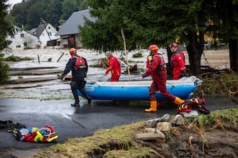 epa11606170 Firefighters carry raft as they prepare for evacuation of people inside house in overfloating Bela river after heavy rain in town of Jesenik, Czech Republic, 15 September 2024. Floods caused by heavy rains have been battering central and eastern Europe since 13 September, with at least four dead in Romania, four missing in the Czech Republic, and alarming water levels recorded in Poland.  EPA/MARTIN DIVISEK