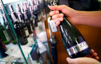 An Italian oenologist checks a bottle of Prosecco wine for authenticity at a food store in Treviso, Italy, on Tuesday, Sept. 3, 2013. Italy's Agriculture Ministry has begun to investigate suspected sales of imitation Prosecco sparkling wine in its native Veneto region. Photographer: Alessia Pierdomenico/Bloomberg via Getty Images