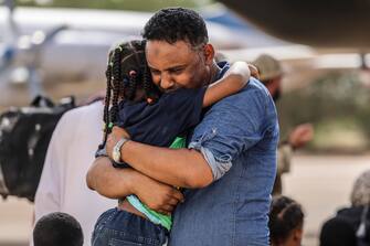 epa10594198 A handout photo made available by the British Ministry of Defence (MOD) of violinist Othmano, hugging his daughter as they wait to board an aircraft for Cyprus, at Wadi Seidna Airport, near Khartoum, Sudan 27 April 2023. The UK has undertaken a military operation to evacuate British nationals from Sudan, due to escalating violence. The operation involved more than 1,200 personnel from 16 Air Assault Brigade, the Royal Marines and the Royal Air Force.  EPA/ARRON HOARE/BRITISH MINISTRY OF DEFENCE HANDOUT -- MANDATORY CREDIT: MOD/CROWN COPYRIGHT -- HANDOUT EDITORIAL USE ONLY/NO SALES