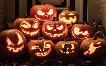 Night shot of illuminated pumpkins in front of a house