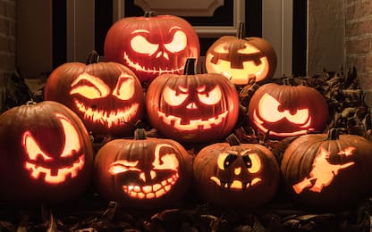 Night shot of illuminated pumpkins in front of a house