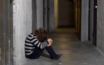 Una ragazza sola seduta per terra