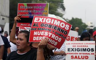 epa11312998 A woman holds a sign reading 'We demand the governmet to respect and fulfill our rights' during a demonstration to mark International Labor Day, in San Salvador, El Salvador, 01 May 2024. Labor Day, or May Day, is observed all over the world on the first day of May to celebrate the economic and social achievements of workers and advocate for their rights.  EPA/JAVIER APARICIO