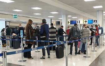 Passeggeri in arrivo all'aeroporto intercontinentale di Fiumicino in attesa di effettuare il test rapido Covid 19 nell'area dello scalo romano messa a disposizione da Aeroporti di Roma