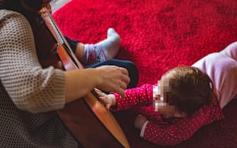 Bambino suona la chitarra con la mamma