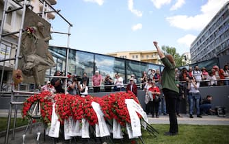 epa12066958 A woman raises her fist as she deposits a wreath at the Worker's monument during a rally marking International Workers' Day, in Thessaloniki, Greece, 01 May 2025. Public transport workers, sea workers and public servants participate in the general strike on Labor Day, or May Day, which is observed worldwide on 01 May to celebrate the economic and social achievements of workers as well as fight for laborers' rights.  EPA/ACHILEAS CHIRAS