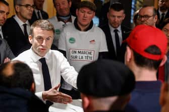 French President Emmanuel Macron (L) gestures in a discussion with French farmers at the Porte de Versailles exhibition centre, on the day of the opening of the 60th International Agriculture Fair (Salon de l'Agriculture), in Paris, on February 24, 2024. Farmers across Europe have been protesting for weeks over what they say are excessively restrictive environmental rules, competition from cheap imports from outside the European Union and low incomes. (Photo by Ludovic MARIN / POOL / AFP) (Photo by LUDOVIC MARIN/POOL/AFP via Getty Images)