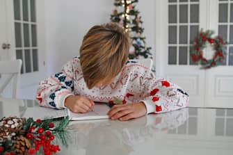 Close-up Of Boy Doing Homework At Christmas Holidays