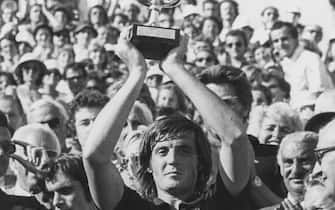 Italian tennis player Adriano Panatta holding his trophy in the air after winning the French Open Tennis Championships at Roland Garros, Paris, 1976. (Photo by Keystone/Hulton Archive/Getty Images)