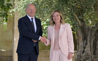 German Chancellor Olaf Scholz is welcomed by Italy's Prime Minister Giorgia Meloni upon arrival at the Borgo Egnazia resort for the G7 Summit hosted by Italy in Apulia region, on June 13, 2024 in Savelletri. Leaders of the G7 wealthy nations gather in southern Italy this week against the backdrop of global and political turmoil, with boosting support for Ukraine top of the agenda. (Photo by Tiziana FABI / AFP)