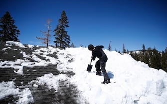 epa10556414 Scott Donahue removes ice off of the roof a house after a recent storm brought 30 inches of snow in less than 24 hours earlier in the week, in Mammoth Lakes, California, USA, 02 April 2023. California's Mammoth Mountain has shattered its all-time snowfall record earlier this week, with more than 700 inches of snow so far this season, as reported by UC Berkeley Snow Lab. The state's snowpack has also reached an all-time high due to 17 atmospheric rivers that have been hitting the state since December, after years of drought.  EPA/CAROLINE BREHMAN