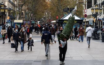 epa08868841 People walk on the Ramblas avenue in Barcelona, Catalonia, north eastern Spain, 07 December 2020. The Catalan Healh Department considers the pandemic situation of Catalonia as 'stable', even though it expects a possible rise in cases due to the re opening of restaurants and cultural events in the region.  EPA/Quique García