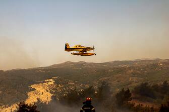 epa10764101 A firefighting aircraft drops water to extinguish a wildfire in Asklipio village, on Rhodes island, Greece, 23 July 2023. Firefighters battle wildfires on the island of Rhodes burning in three active fronts. The fire operation is focused on preventing the fire from spreading further as strong winds cause constant rekindling of the fire. The Dodecanese Islands Police Directorate said the several villages and towns were evacuated for preventative reasons and visitors at hotels in areas affected by wildfires. Tour operators have additionally ordered charter flights to land at Rhodes without passengers in order to pick up travelers who wish to leave the island.  EPA/DAMIANIDIS LEFTERIS