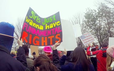 Crowds of women and men holding protest signs march through the streets during the Women's March on Washington, D.C.. Prominent sign says, "Girls Just Wanna Have Fundamental Rights." Protest. March. Community. Togetherness.